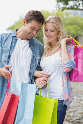 Hip young couple looking at their shopping bags