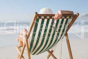 Woman relaxing in deck chair by the sea