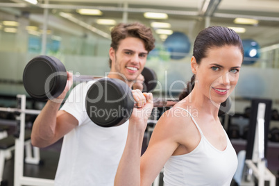 Fit couple lifting barbells together