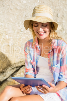 Pretty blonde using tablet pc at the beach