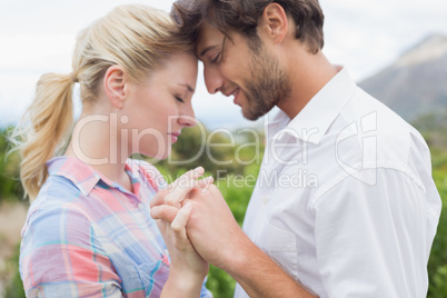 Cute affectionate couple standing outside holding hands