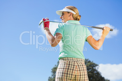 Female golfer standing holding her club