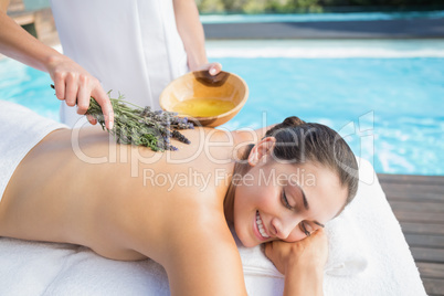 Smiling woman getting an aromatherapy treatment poolside