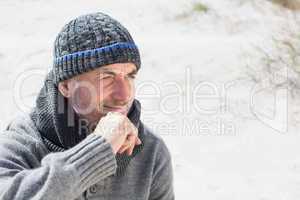 Attractive man smiling on the beach in hat and scarf