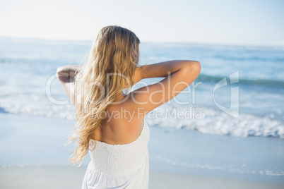 Beautiful blonde in white sundress on the beach