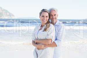 Happy couple hugging on the beach woman looking at camera