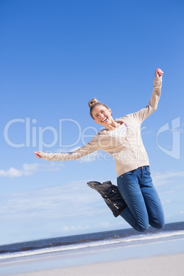 Pretty blonde in jeans jumping and smiling at camera