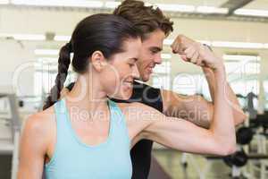 Fit attractive couple comparing biceps