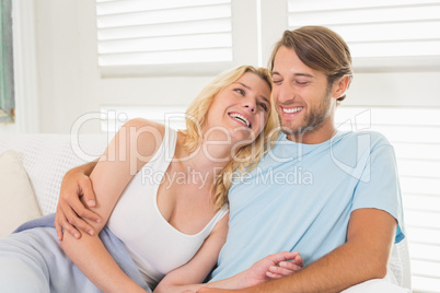 Young couple sitting on the couch laughing