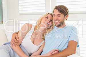 Young couple sitting on the couch laughing