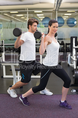 Fit couple lifting barbells together