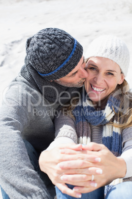 Attractive couple on the beach in warm clothing