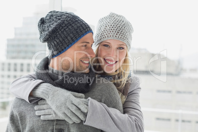 Cute couple in warm clothing hugging woman smiling at camera