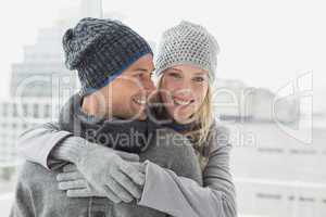 Cute couple in warm clothing hugging woman smiling at camera