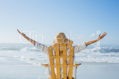 Woman relaxing in deck chair by the sea