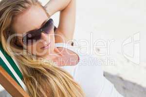 Gorgeous blonde in sunglasses sitting at the beach