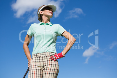 Female golfer standing with hand on hip