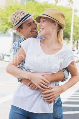 Young hip couple hugging and smiling at each other