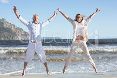 Happy couple jumping on the beach together