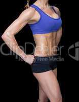Female bodybuilder posing with hands on hips mid section