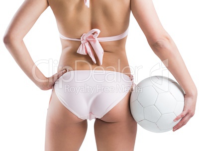 Fit girl in bikini holding football