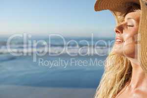 Gorgeous blonde in straw hat smiling on beach