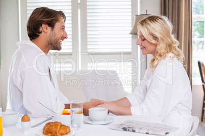 Cute couple having breakfast in their bathrobes