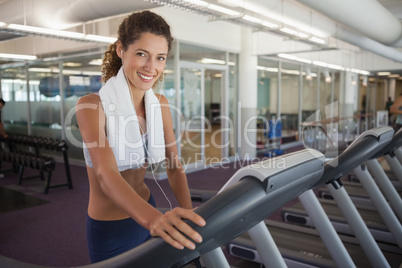 Fit woman wearing towel around shoulders on the treadmill