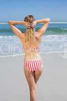 Blonde fit woman in striped bikini at beach