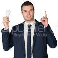 Businessman holding light bulb and pointing