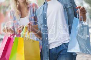Cute young couple holding shopping bags