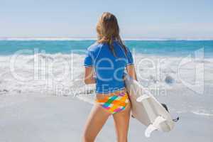 Fit surfer girl on the beach with her surfboard