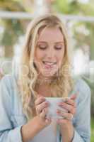 Pretty blonde sitting at table having coffee