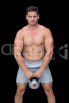 Focused bodybuilder lifting up kettlebell