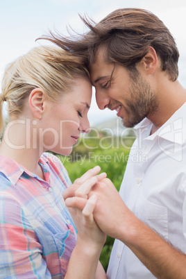 Cute affectionate couple standing outside holding hands