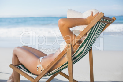 Slim woman relaxing in deck chair on the beach