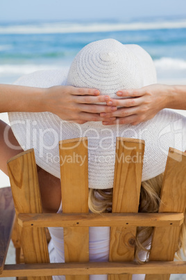 Woman sitting in deck chair at the beach