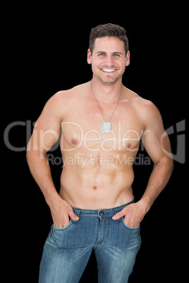 Handsome muscular man posing in blue jeans smiling at camera