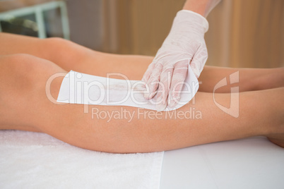 Woman getting her legs waxed by beauty therapist