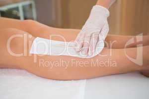 Woman getting her legs waxed by beauty therapist