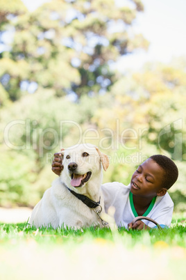 Cute little boy lying with labrador dog