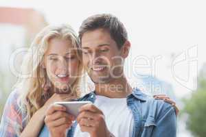 Cute young couple looking at smartphone