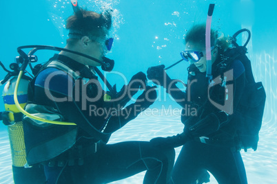 Man proposing marriage to his shocked girlfriend underwater in s