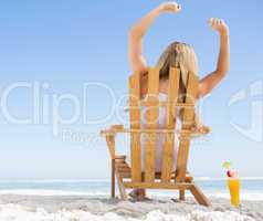 Pretty blonde sitting in deck chair with a cocktail