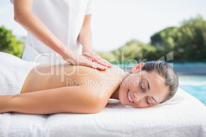 Happy brunette getting a massage poolside
