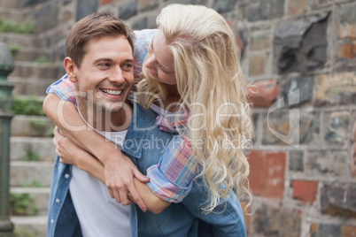 Man giving his pretty girlfriend a piggy back