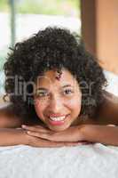 Gorgeous woman lying on massage table smiling at camera