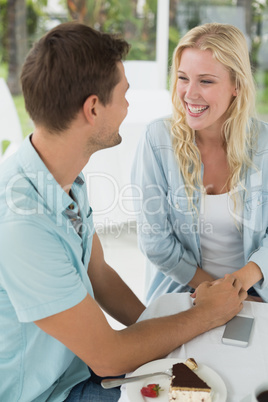 Hip young smiling couple having desert together