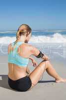 Fit woman sitting on the beach taking a break