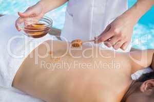Woman getting a honey beauty treatment poolside